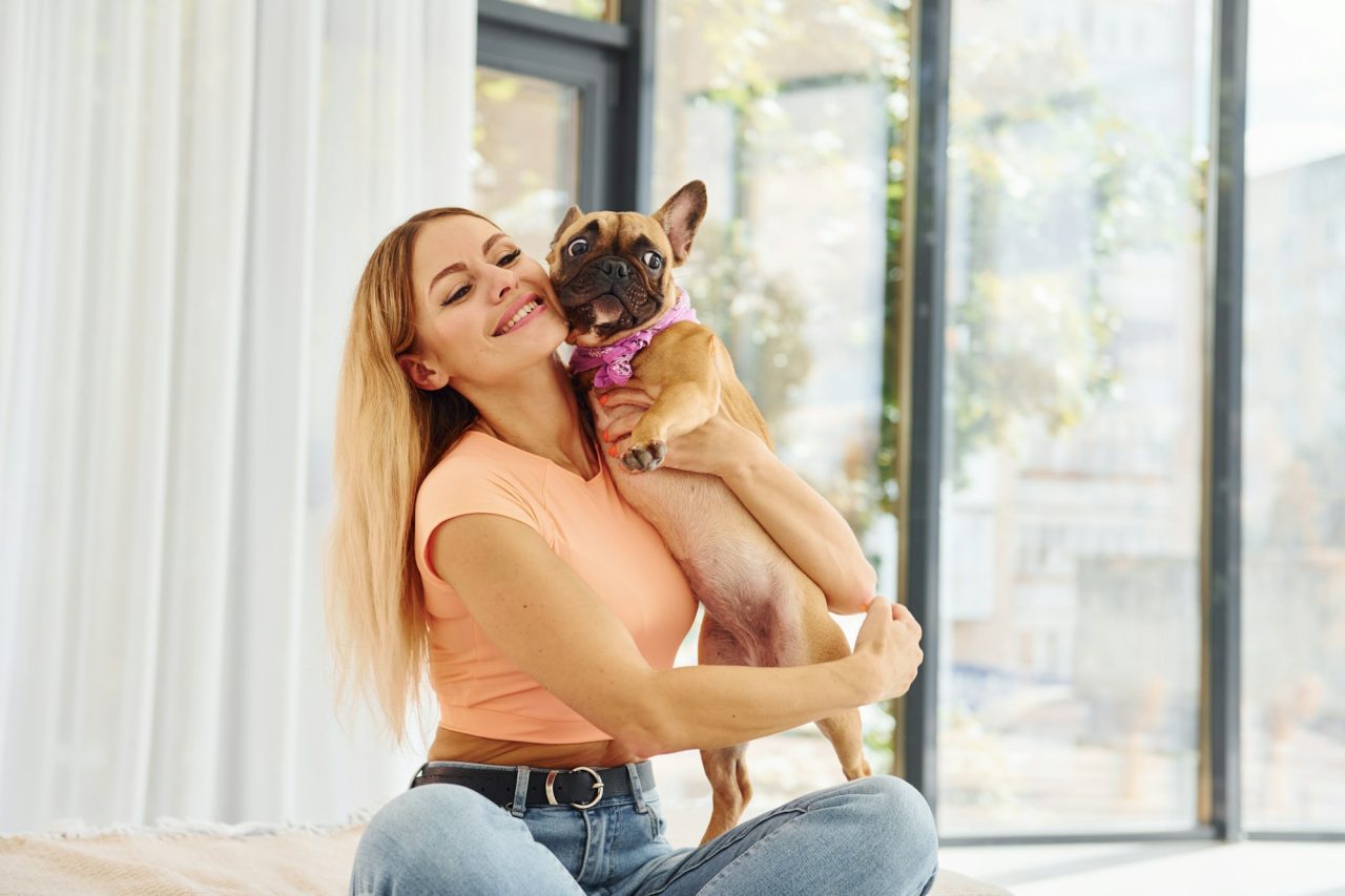 Mujer abrazando a su perro en casa